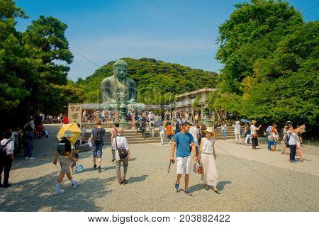 TOKYO, JAPAN JUNE 28 - 2017: Crowd of people posing and taking pictures at monumental bronze statue of the Great Buddha in Kamakura, Japan.