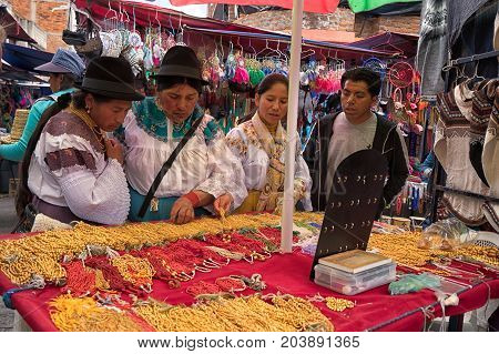 April 29 2017 Otavalo Ecuador: indigenous quechua women in front of a jewelry stand in the Saturday market