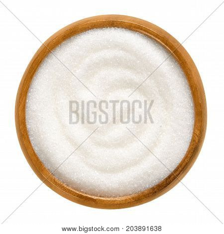 Fine granulated white sugar in wooden bowl. Crystals of refined table sugar. Sweet soluble carbohydrates. Sucrose, disaccharide of glucose and fructose. Macro food photo close up from above over white