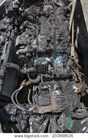 Burned and damaged car engine after fire accident