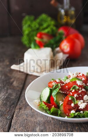 Shopska Salad In A White Plate On A Wooden Background, A Number Of Raw Ingredients Lettuce.
