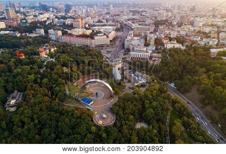 Panoramic view of a modern city at sunset. Skyline bird eye aerial view of the old part of the city under dramatic cloud sunset sky. General view of the right bank of Kiev with Arch of Friendship of Peoples, Khreshchaty Park, the main street of the city -
