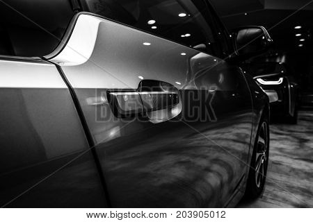 BERLIN - NOVEMBER 28 2014: Showroom. A fragment of the BMW i3 previously Mega City Vehicle (MCV) is a five-door urban electric car developed by the German manufacturer BMW. Black and white.