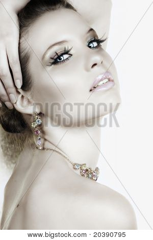 Hermosa mujer rubia con pestañas largas y coloridas piedras collares y aretes y seductora smil