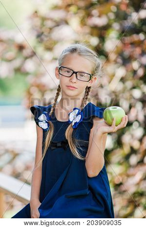 Adorable little school girl with notes and pencils outdoor.