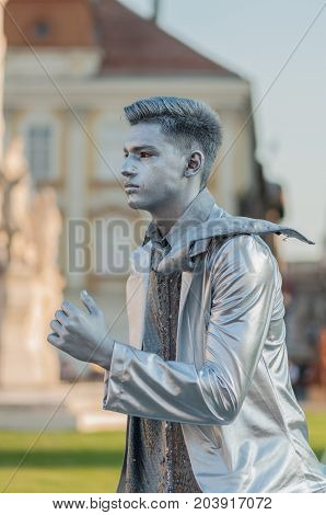 TIMISOARA, ROMANIA - September 08, 2017: Portrait of a man in silver costume at the CheckArt Carnaval. Living statue. Union Square.