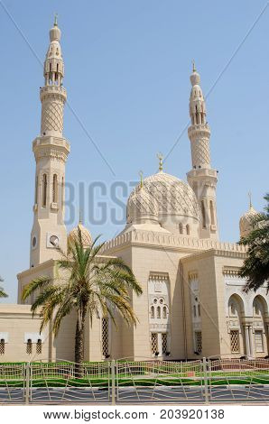 DUBAI UNITED ARAB EMRATES - 9 SEPTEMBER 2017: Wide shot of Jumeirah Mosque and palm trees with blue sky in Dubai United Arab Emirates
