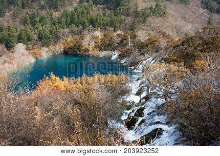 Waterfalls in JiuZhaiGou. Jiuzhaigou , Sichuan, China. Picturesque nature in JiuZhaiGou. Flow of water over the rocks into the lake against the backdrop of mountains and sky