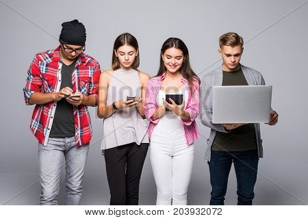 Beautiful Young People Of Different Nationalities Are Using Gadgets And Smiling, Standing Against Wh