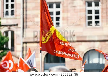 STRASBOURG FRANCE - SEPT 12 2017: Young communist movement flags at political march during a French Nationwide day of protest against the labor reform proposed by Emmanuel Macron Government