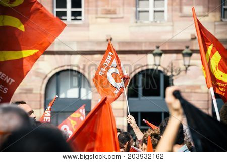 STRASBOURG FRANCE - SEPT 12 2017: Young communist movement flags at political march during a French Nationwide day of protest against the labor reform proposed by Emmanuel Macron Government