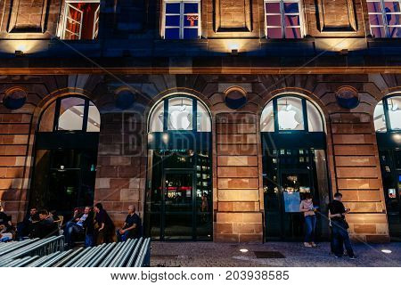 STRASBOURG FRANCE - SEPT 18 2014: Night view of Apple Store facade builing with impatient customers waiting in queue and tents for the upcoming Apple iPhone Apple Watch and other new products