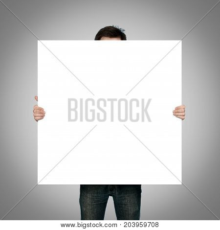 man holding blank paper on gray background