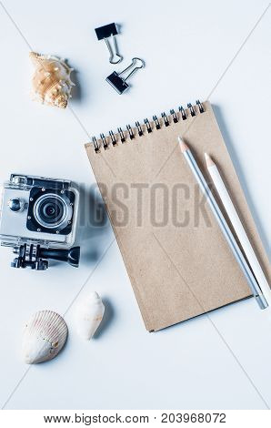Action camera shells and notebooks on a light background. The concept of memories or dreams