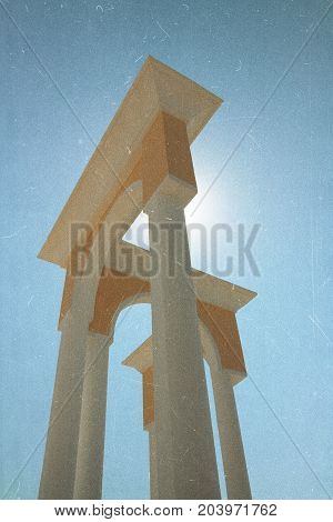 Architecture. Retro film effect image. Arch columns against the sky in front of the sun