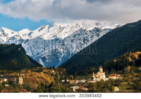 View of Svanetian towers and church in Mestia village against mountains with glaciers snow peaks. Upper Svaneti Georgia. Georgian landmark