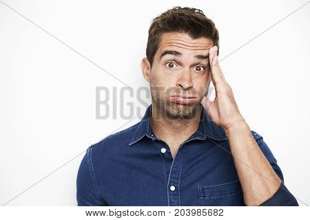 Disbelieving dude in blue shirt portrait studio