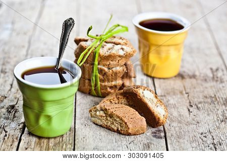 Two cups of coffee and fresh Italian cookies cantuccini with almond nuts on ructic wooden table background. Italian breakfast.