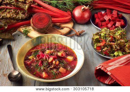 Spring Food Background With Red Beet Vegetable Soup. Ingredients: Red Beet Root, Fresh Beet Leaves, 