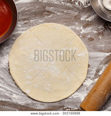 Raw Dough For Pizza Base On Floured Surface, Top View, Crop
