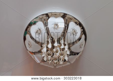 Modern Chandelier Made Of White Glass On A White Ceiling