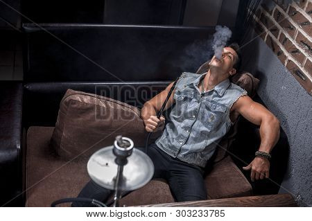 Handsome Guy Smoking Shisha In The Hookah Bar.