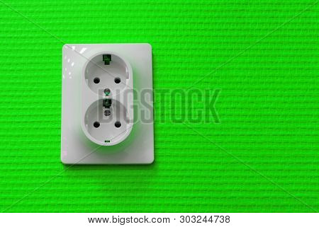 Electrical Outlet On A Green Wallpaper Wall