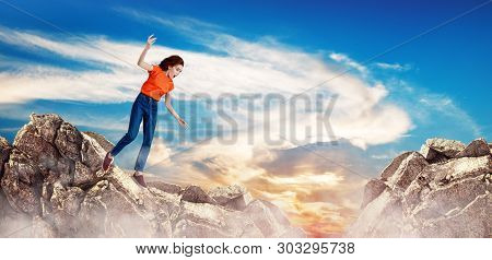 Redhead Woman Falling Down Between Hills On Cliff On Blue Sky Background.
