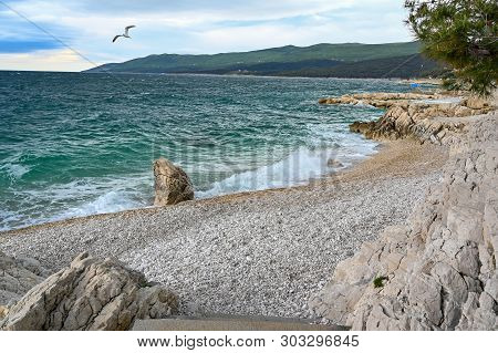 Waves Coming And Going On A Pebbely Beach
