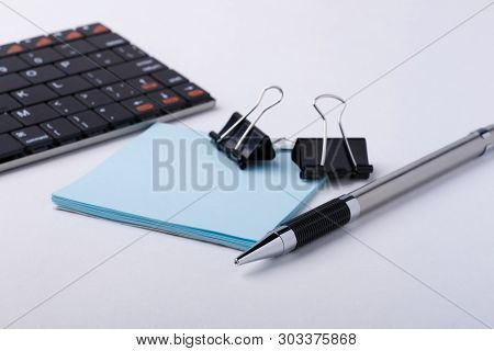 Pen, Stickers, Binder Clips And Wirless Keyboard On White Background. Selective Focusing