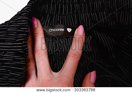 Kharkov, Ukraine - April 27, 2019: Black Chicoree Tag In Female Hand On Black Striped Clothing. Clos