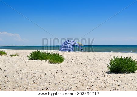 Clean, Sandy Beach Against The Blue Sea. Landscape On A Wild Beach. The Sea In The Summer.