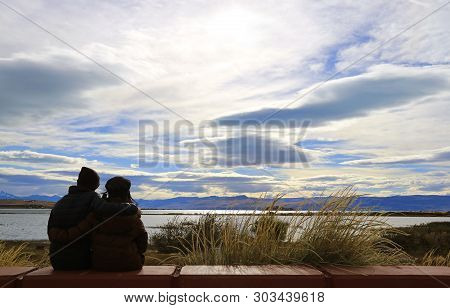 Silhouette Of A Happy Couple Relaxing On Argentino Lake Shore In El Calafate, Patagonia, Argentina, 
