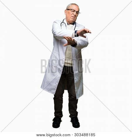 Handsome senior doctor man wearing medical coat disgusted expression, displeased and fearful doing disgust face because aversion reaction. With hands raised. Annoying concept.