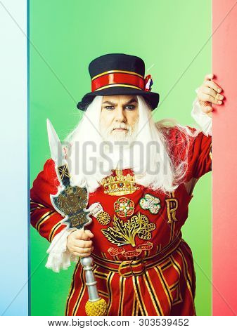 Frown Senior Man Beefeater Yeomen Warder Or Male Royal Guard Bodyguard In Red Uniform With Spear On 