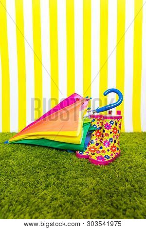 Bright Baby Boots With Multicolored Umbrell. Background