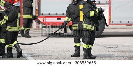 Firefighter With Apparatus And More People During A Fire Drill