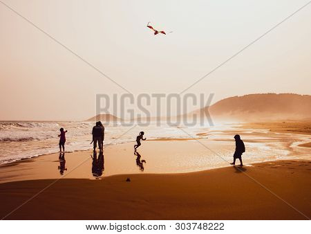 Karpasia, Cyprus - 14 April, 2019: Atmospheric Capture Of Silhouettes Of People Playing And Flying A