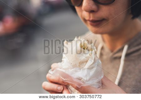 woman eat traditional Taiwanese snack of spring roll