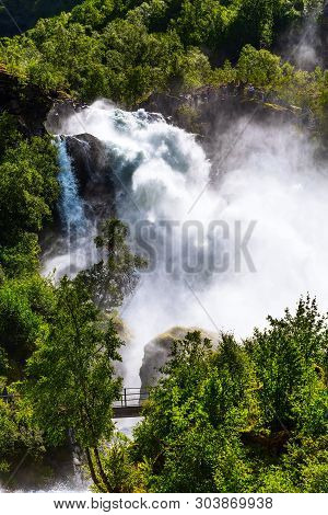 Waterfall Briksdal Or Briksdalsbreen Glacier In Olden, Norway And Green Mountains,