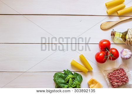 Cannelloni, Tomatoes, Minced Meat And Other Ingredients. White Wooden Background. Italian Cuisine.