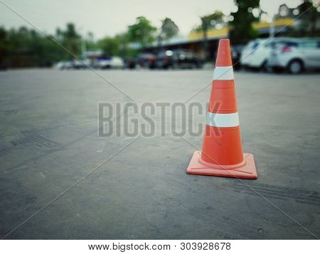 Red Rubber Cone On Concrete Floor In Gas Station, Blurred Background Image