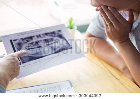 Dental Hygienist Demonstrating And Showing A Dummy Jaw To Chack-up Or Healing Teeth  Patient