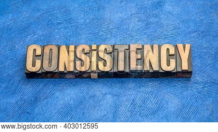 consistency word abstract in vintage letterpress wood type against handmade paper
