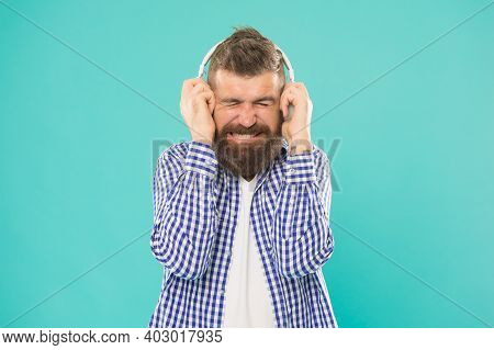 Unhappy Bearded Man In Casual Checkered Shirt Listen Song In Heaphones And Suffer From Loud Sound On