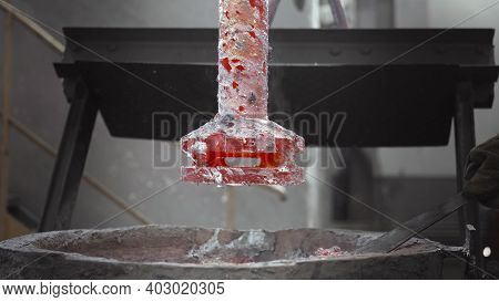Worker Removes Slag From A Barrel With Molten Metal