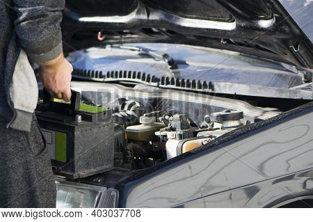Put The Battery In The Car, Auto Repair. An Auto Mechanic Is About To Put In The Battery And Tighten