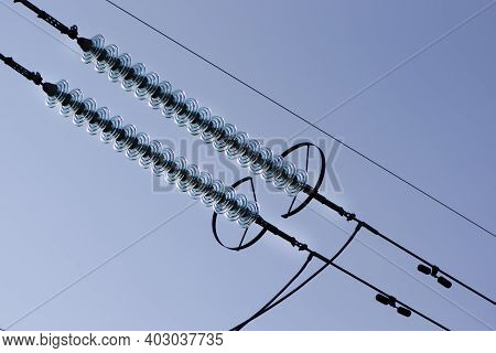 Power Line Of Cables And Insulators Close Up. Electrical Insulators Support Cables Placed On Bracket
