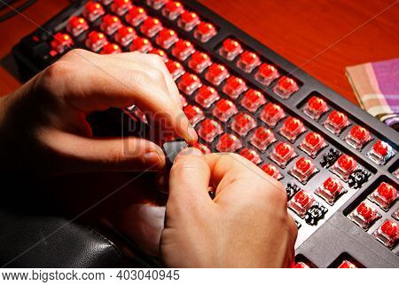 Man Is Holding In Hands Black Keyboard Button. Glowing Red Keyboard Switches. Gaming Mechanical Comp