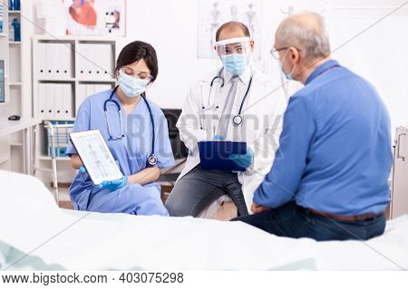 Healthcare Physician Explaining Human Anatomy To Senior Man Showing Tablet Pc In Time Of Covid Pande